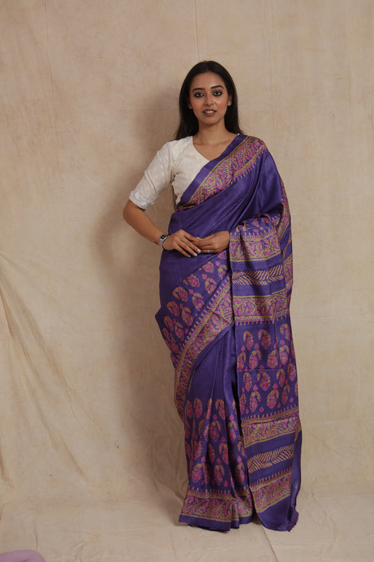 Front view of royal purple Tassar printed saree with floral motifs and paisley border