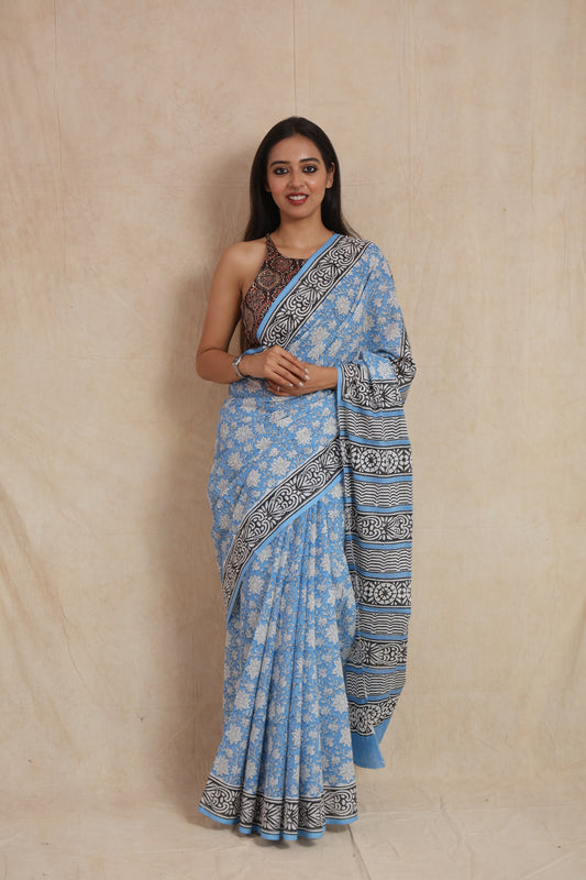 Front view of a sky blue cotton saree featuring white floral prints and a black and white printed border.