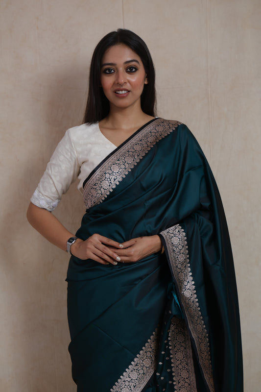 Close-up of midnight teal Banarasi art silk saree showcasing intricate woven border and luxurious texture