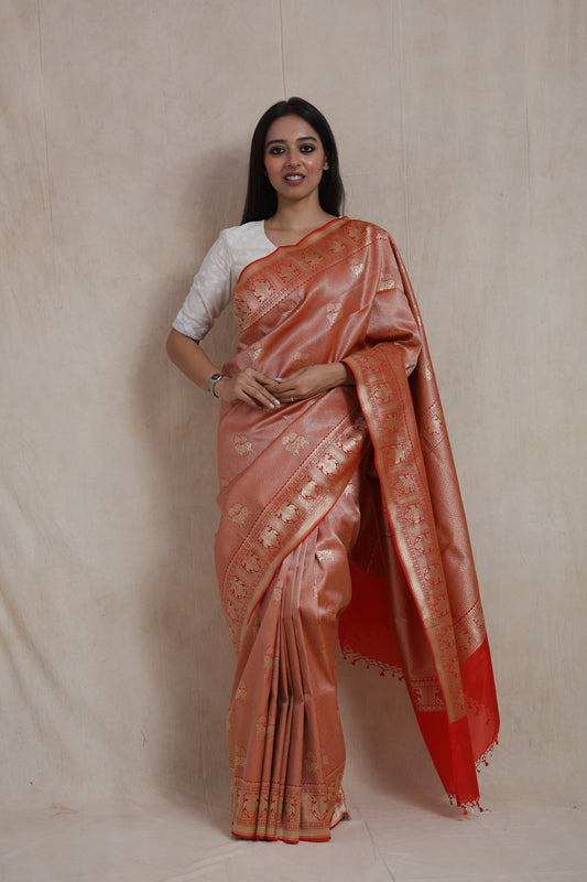 Front view of rose gold Banarasi silk saree with woven elephant motifs and coral red contrast pallu