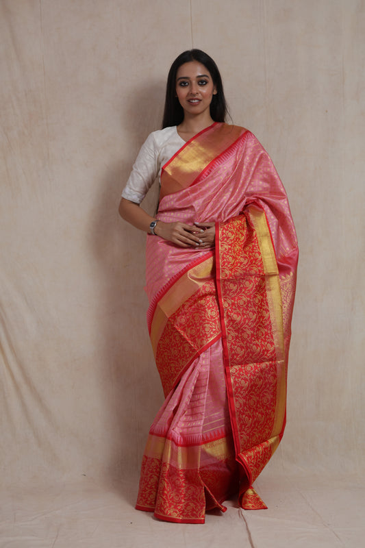 Front view of a blush pink Venkatgiri silk saree featuring gold woven checks, broad border, and rich red floral pallu.