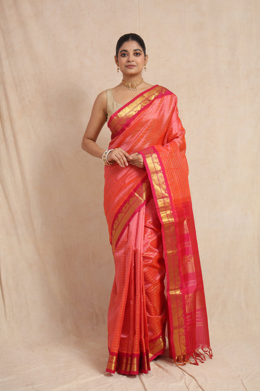 Model wearing coral pink Kanchipuram Handloom SICO saree with rani pink woven border