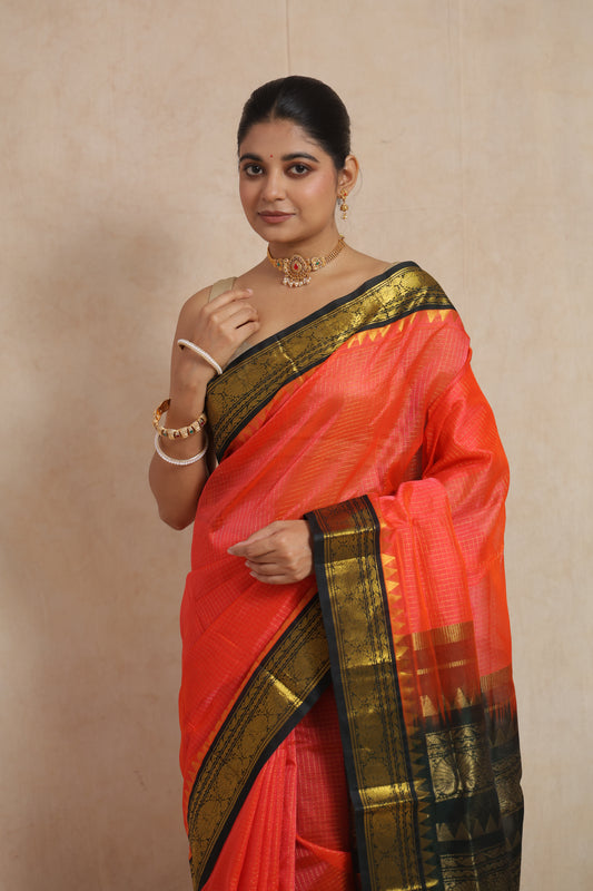 Portrait view of coral orange handloom SICO saree featuring traditional woven border