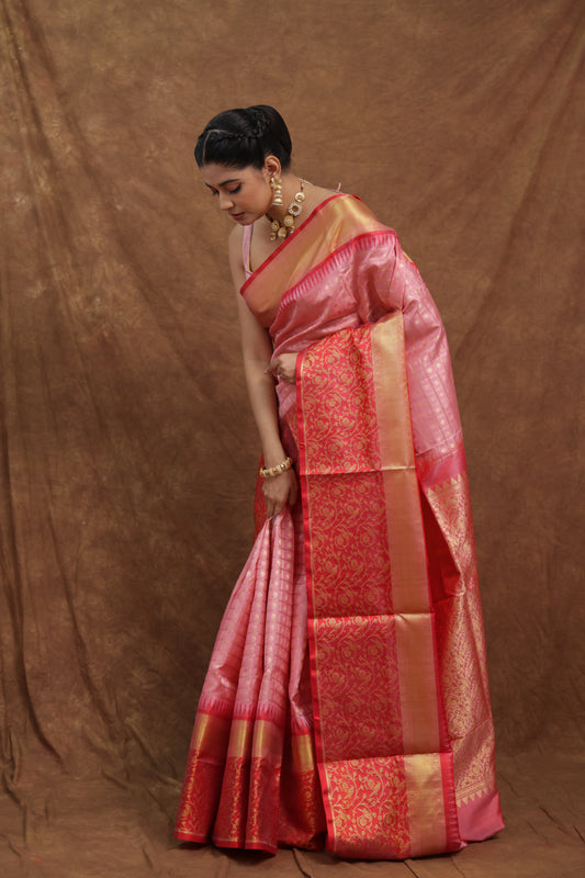 Blush pink Kanchipuram silk saree with deep red woven border, showcasing intricate traditional craftsmanship.