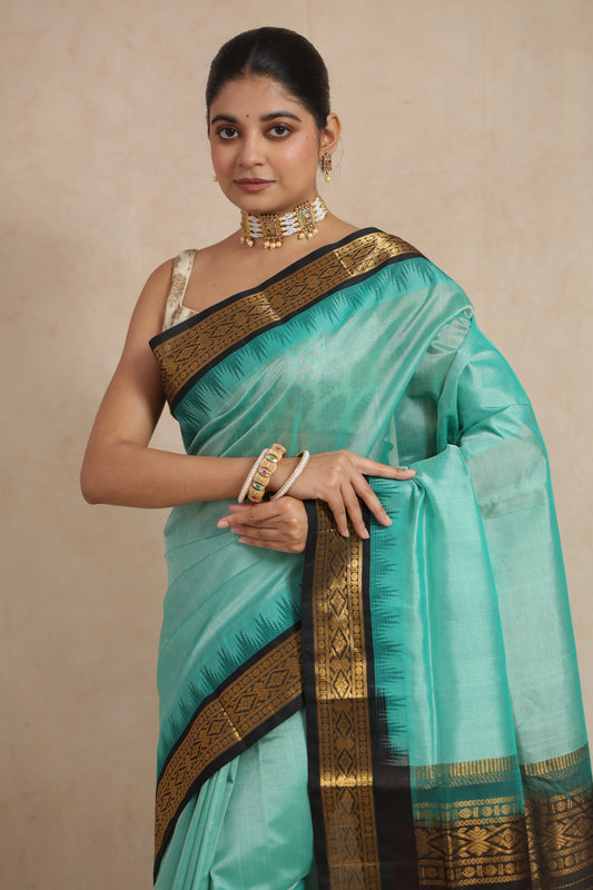 Close-up of aqua blue Kanchipuram Sico saree featuring antique gold zari border