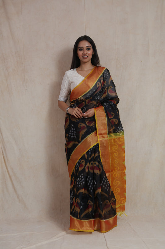 Full-length view of Panchampali silk cotton saree with black body and vibrant orange patterned pallu