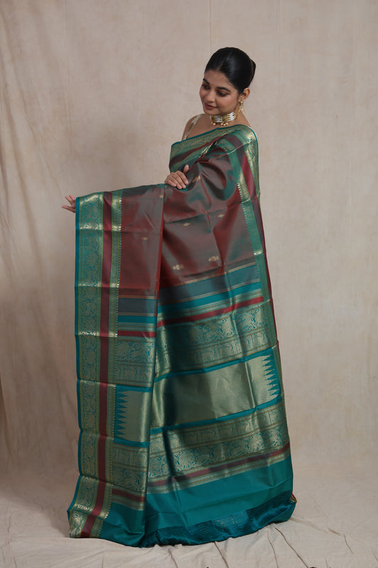 Front pose of dual-tone maroon teal Kanchiwaram silk saree with rich zari border