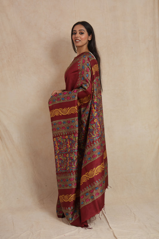 Side profile of deep maroon Batik silk saree with colorful handcrafted motifs