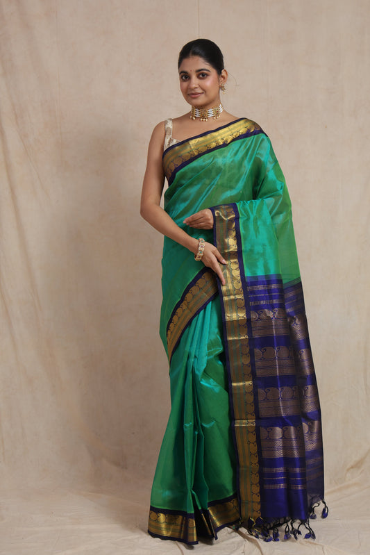 Full view of elegant emerald green Kanchipuram Sico saree with royal blue contrast border
