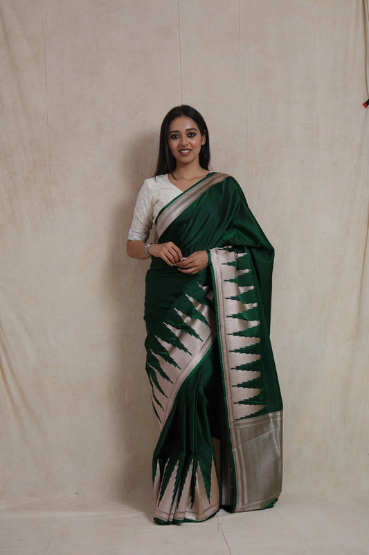 Full-length view of emerald green Banarasi art silk saree with ornate silver border and pallu