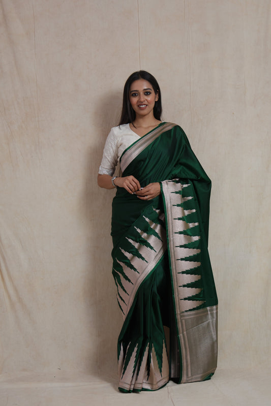 Full-length view of emerald green Banarasi art silk saree with ornate silver border and pallu