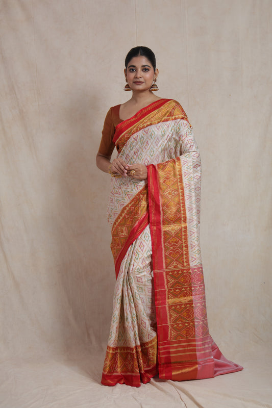 Full-length view of ivory white Patola handloom silk saree with ornate red woven border and pallu