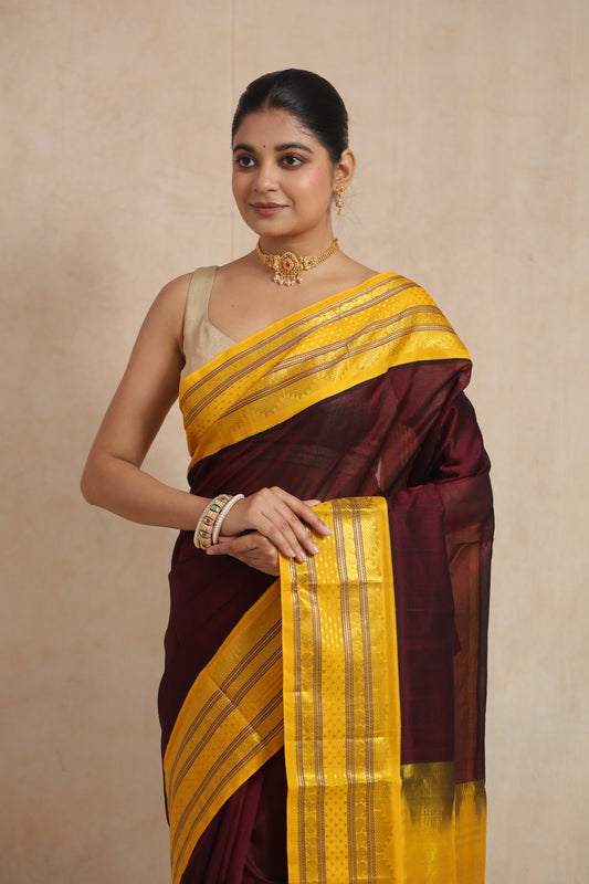 Close-up of maroon Kanchipuram SICO saree highlighting the rich yellow border and traditional woven patterns