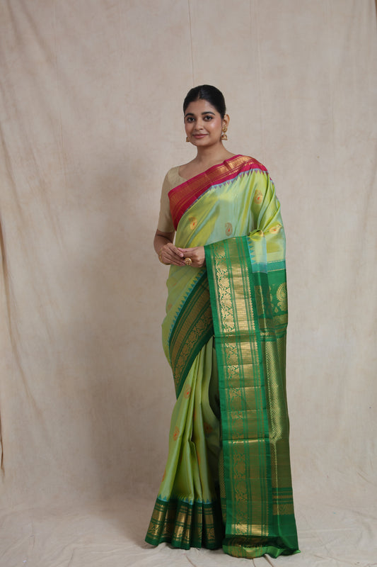 Front view of pastel lime green Gadwal Sico saree with emerald green woven border