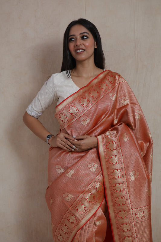 Close-up of rose gold Banarasi silk saree with traditional elephant motif weaving and rich contrast accents