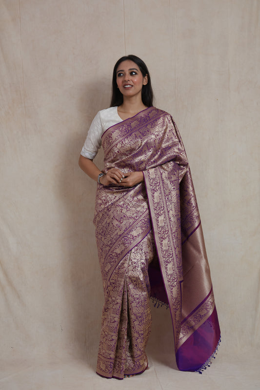 Elegant drape of royal purple Banarasi silk saree featuring rich woven zari motifs.