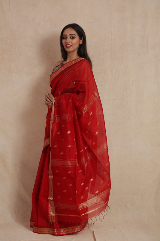 Ruby red Maheshwari Sico saree with golden woven border, showcasing elegant drape and intricate design by Joyee Kolkata.