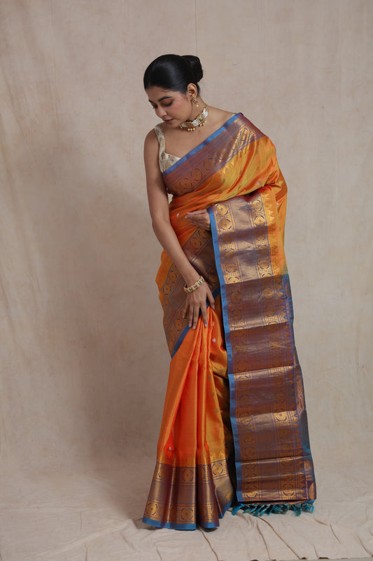Elegant drape of orange Gadwal silk saree with contrast blue pallu