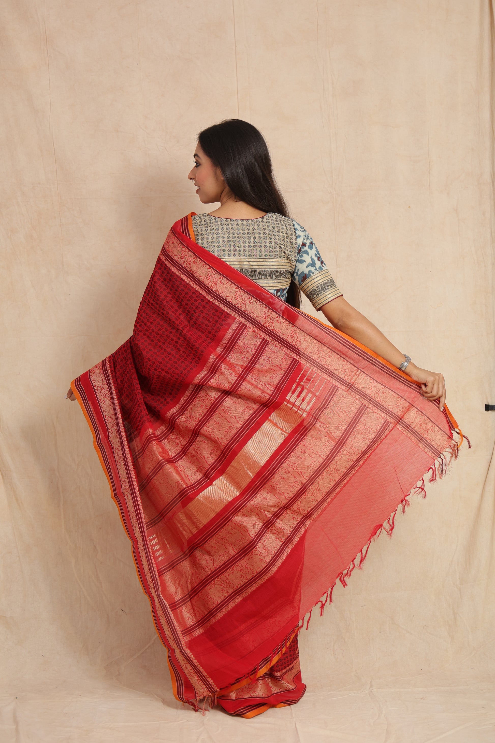 Back view of ruby red handloom cotton saree showcasing the woven pallu design