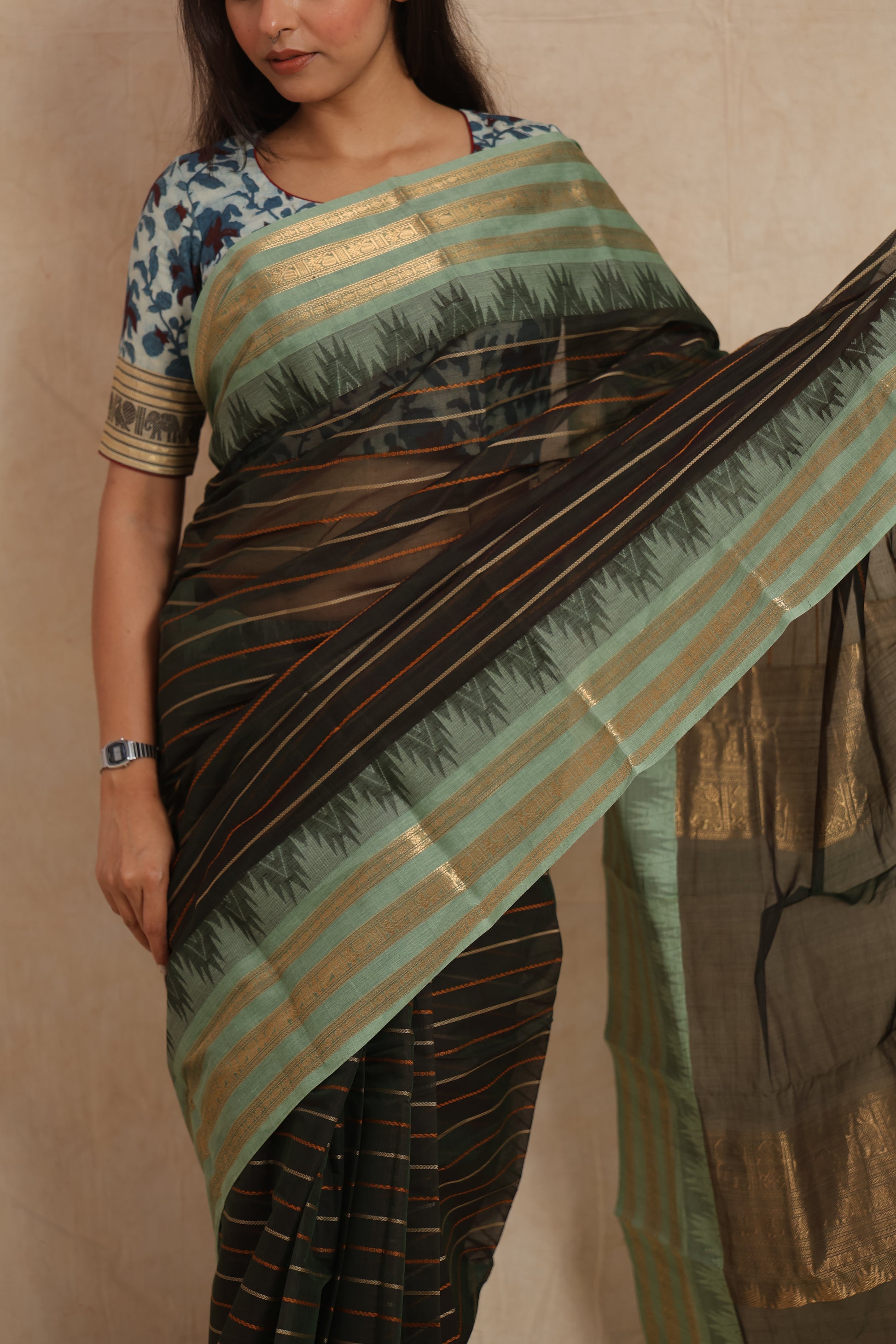 Close-up of black Kanchipuram cotton saree with mint green border detailing