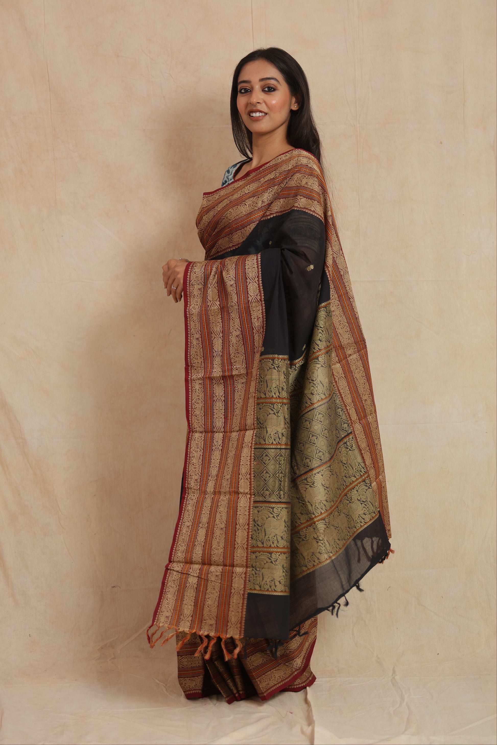 Side profile of black Kanchipuram cotton saree showcasing intricate woven border details