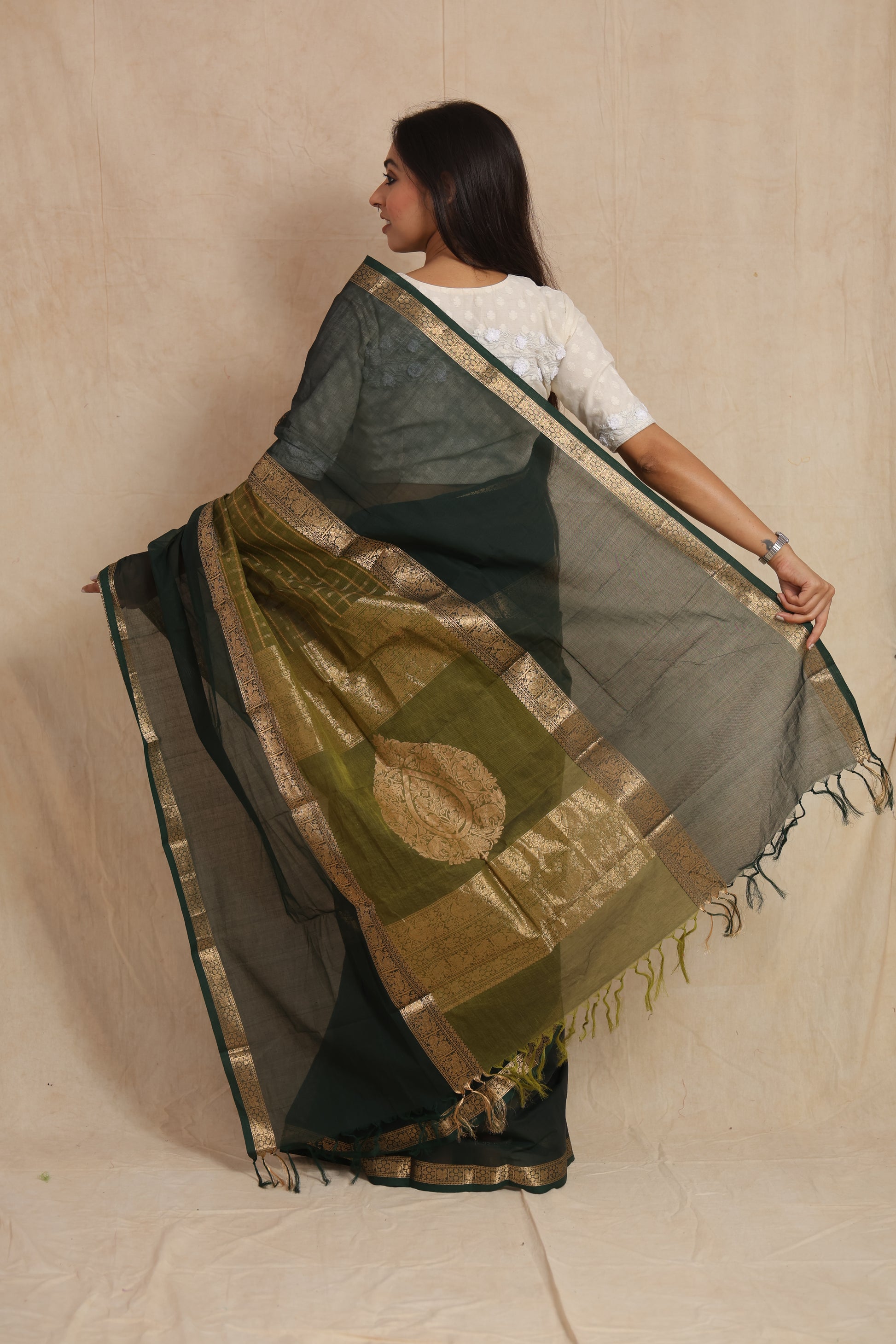 Back drape view of deep green Kanchipuram handloom cotton saree with ornate pallu