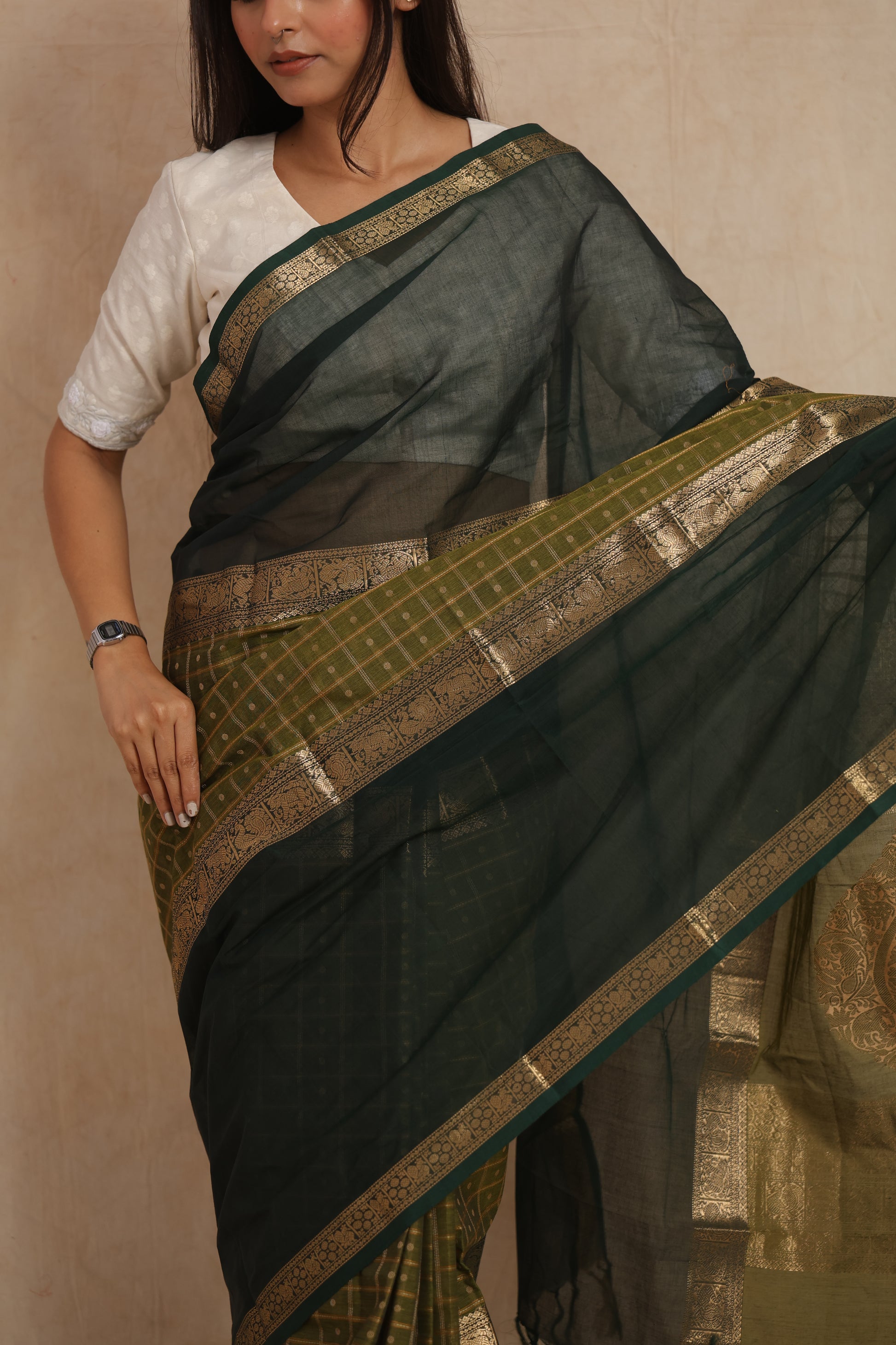 Close-up of deep green Kanchipuram cotton saree with woven motifs and border