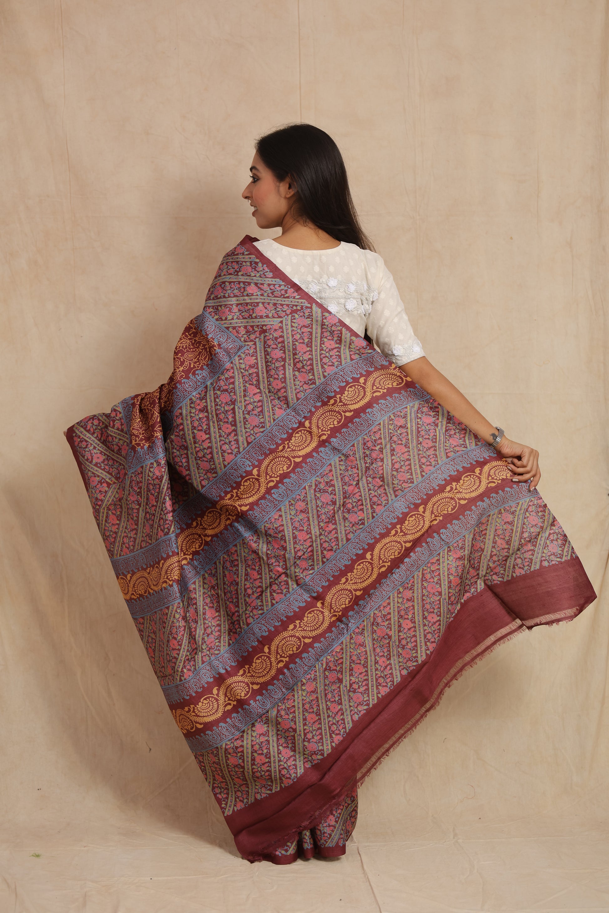 Detailed close-up of floral vine and paisley print on maroon Tussar silk saree
