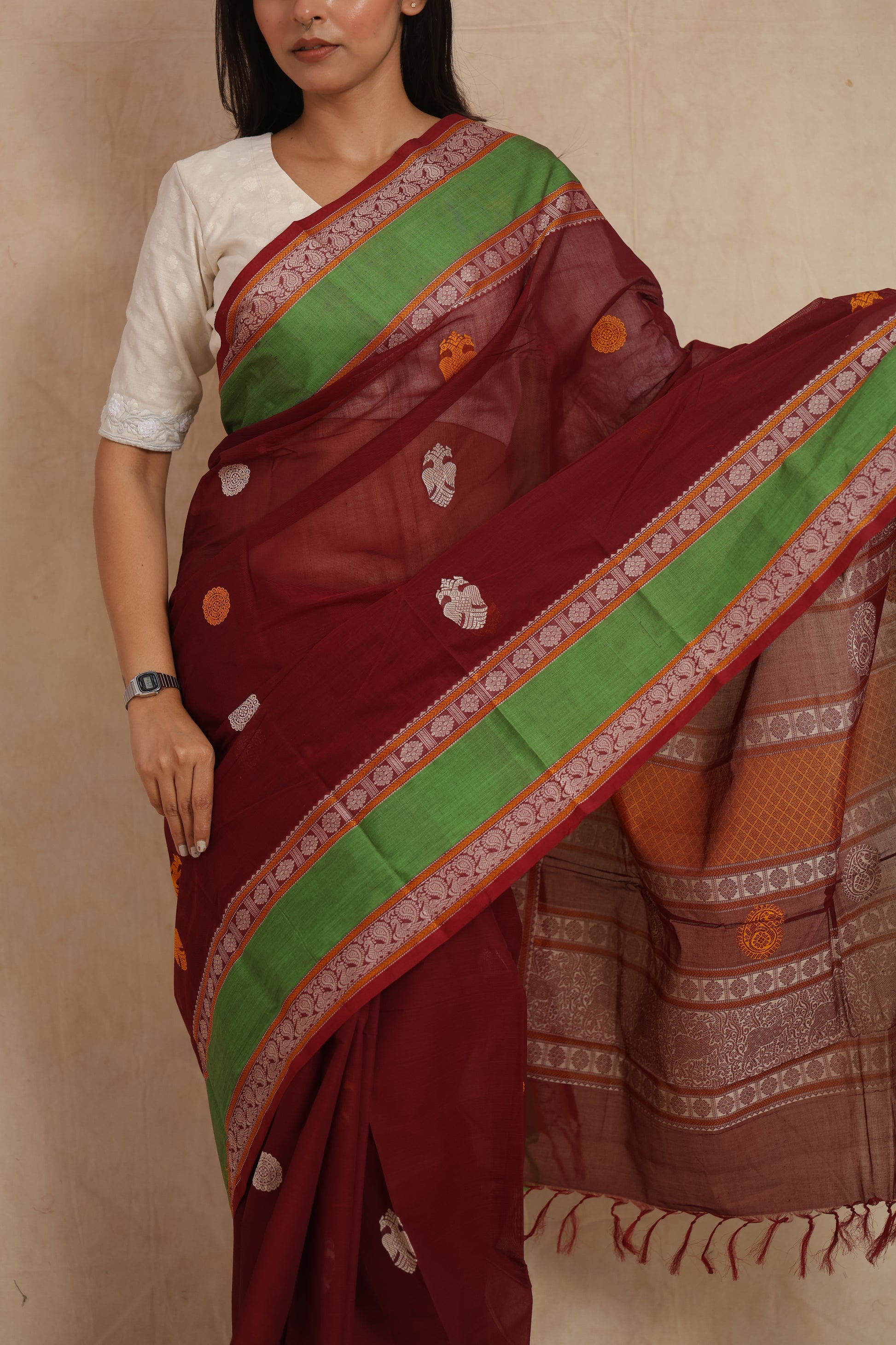 Detailed view of maroon Kanchipuram cotton saree with woven motifs and green border