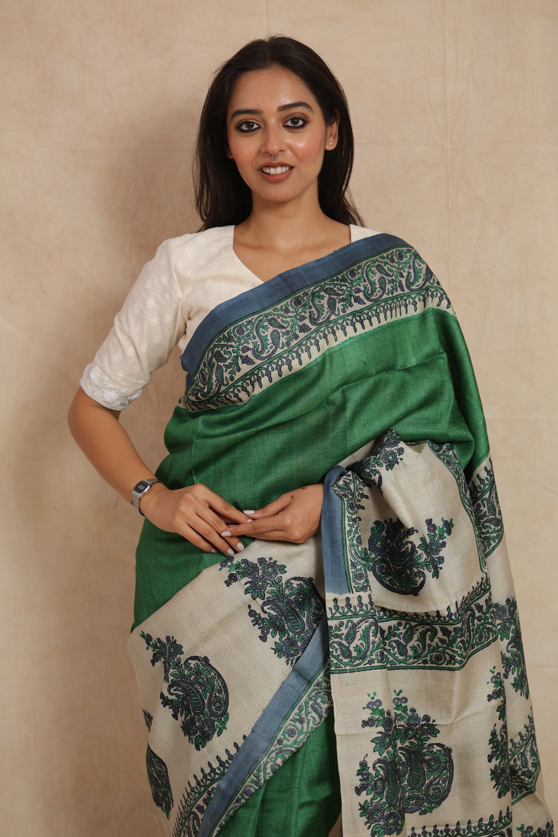 Portrait view of model wearing emerald green printed Tussar silk saree