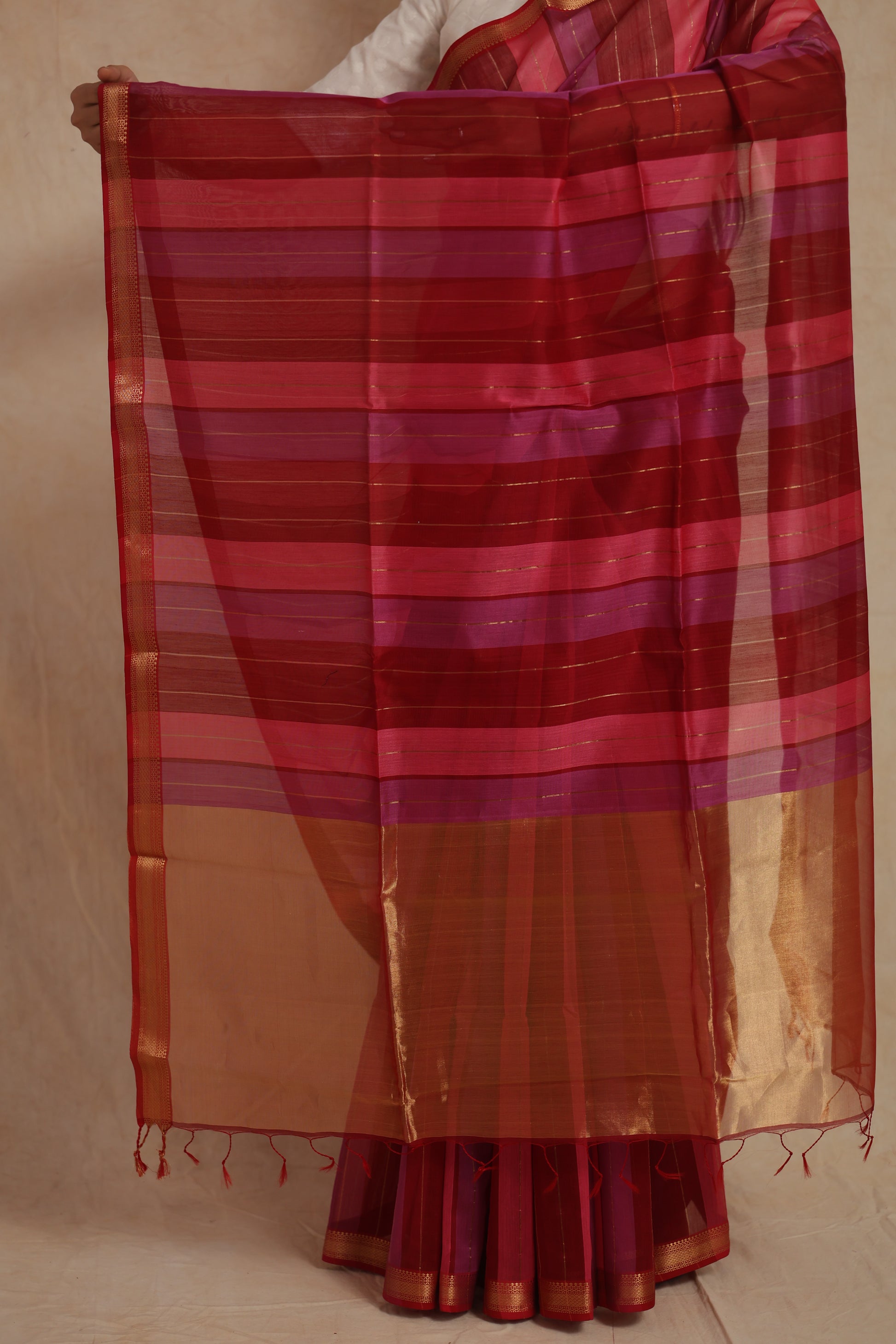Detailed view of the striped pallu of the Maheshwari cotton saree with traditional gold border and tassels.
