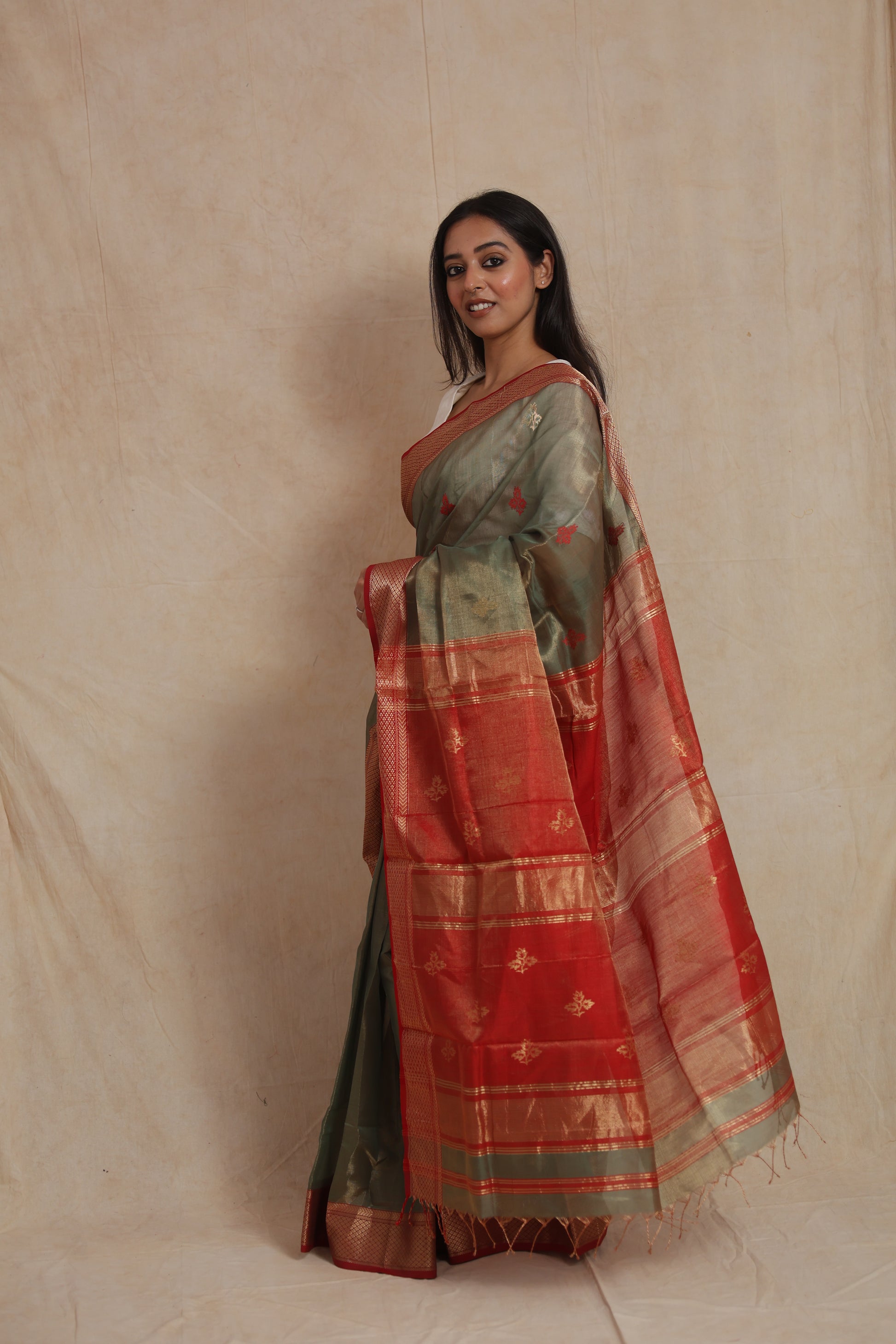 Side profile of olive green Maheshwari handloom silk cotton saree with red pallu