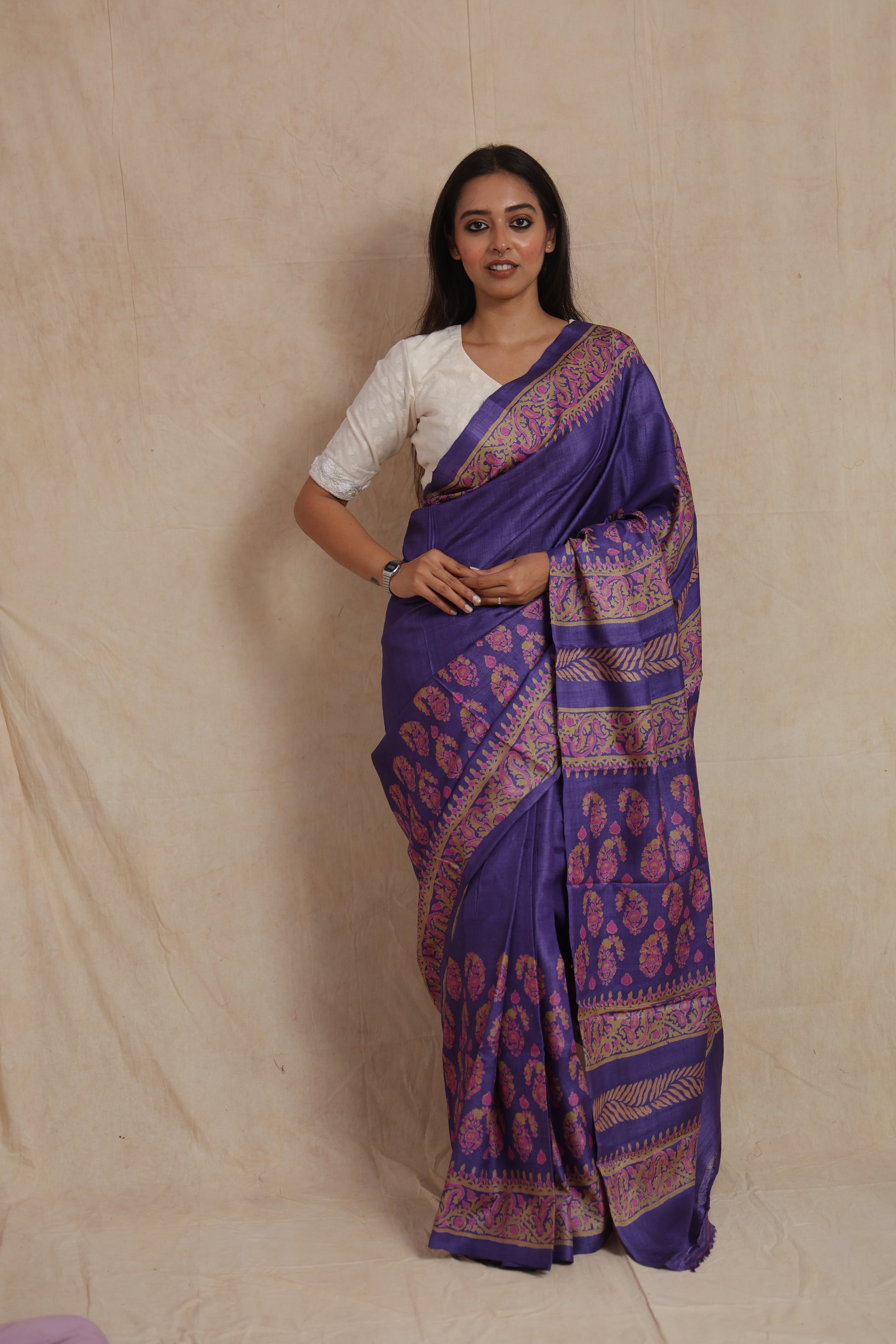 Front view of royal purple Tassar printed saree with floral motifs and paisley border