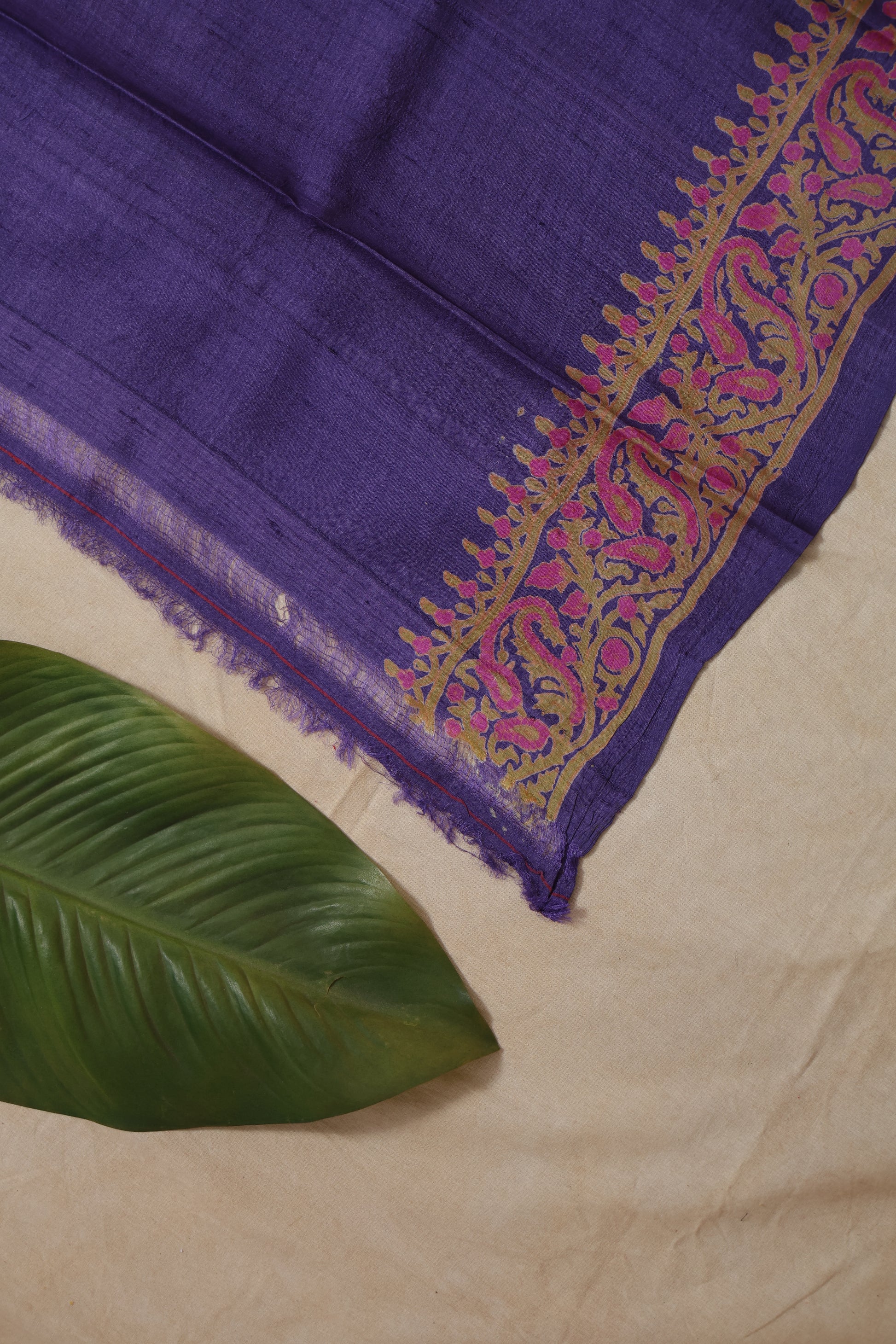 pallu display of purple Tassar printed saree featuring floral and leaf motifs