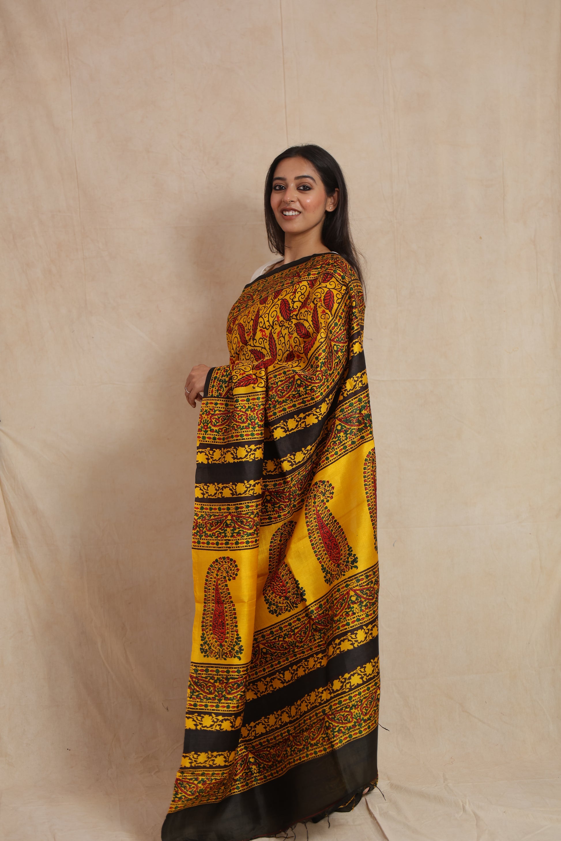 Side view of mustard yellow Batik silk saree featuring detailed traditional pallu design