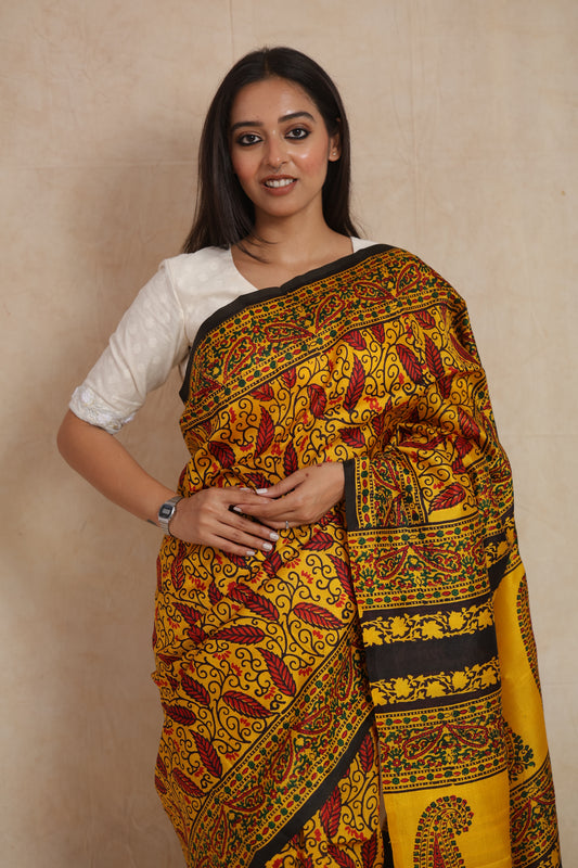 Close-up of mustard yellow Batik silk saree with intricate leaf and vine motifs