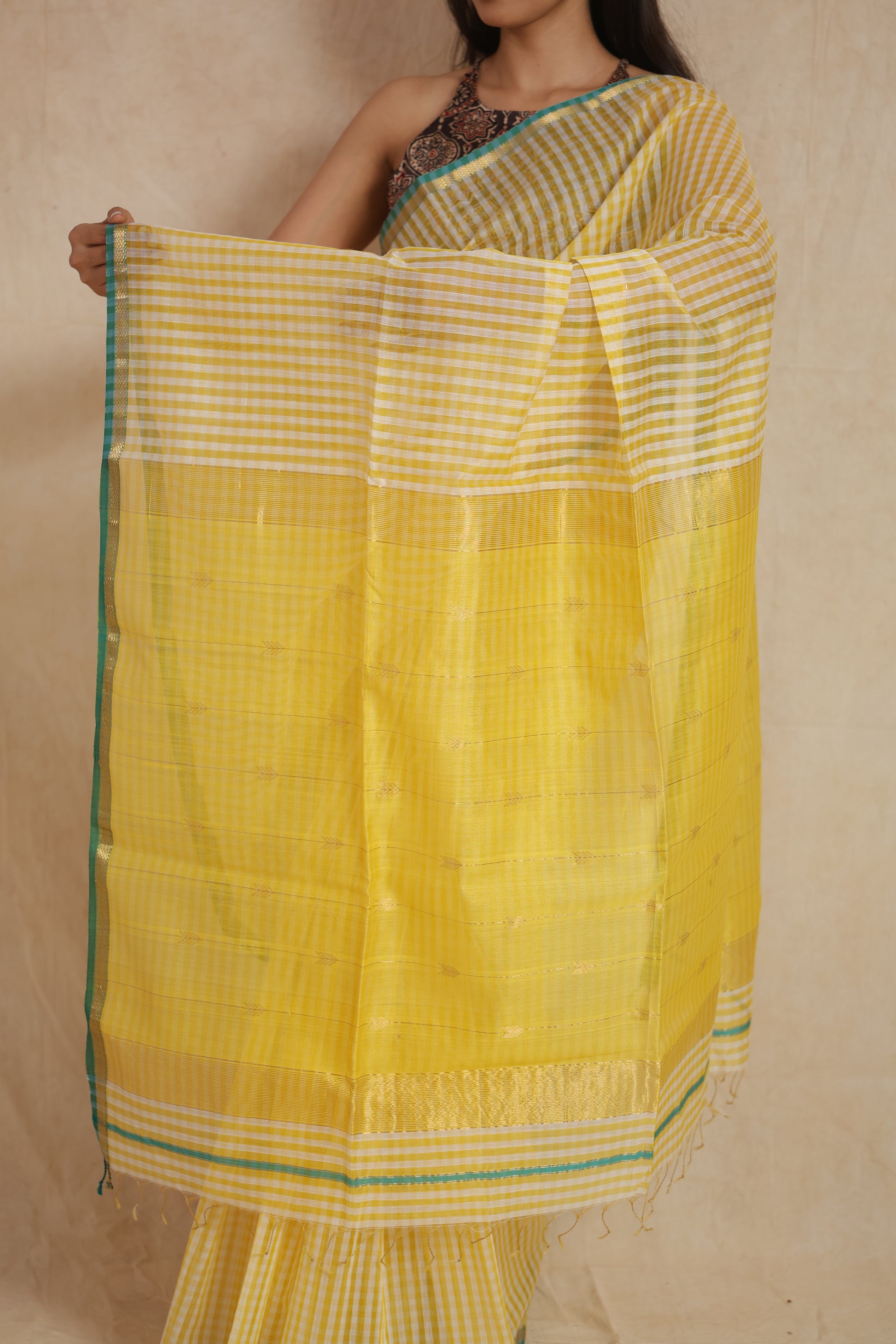 Close-up of sunshine yellow Maheshwari handloom silk saree highlighting checked weave and pallu