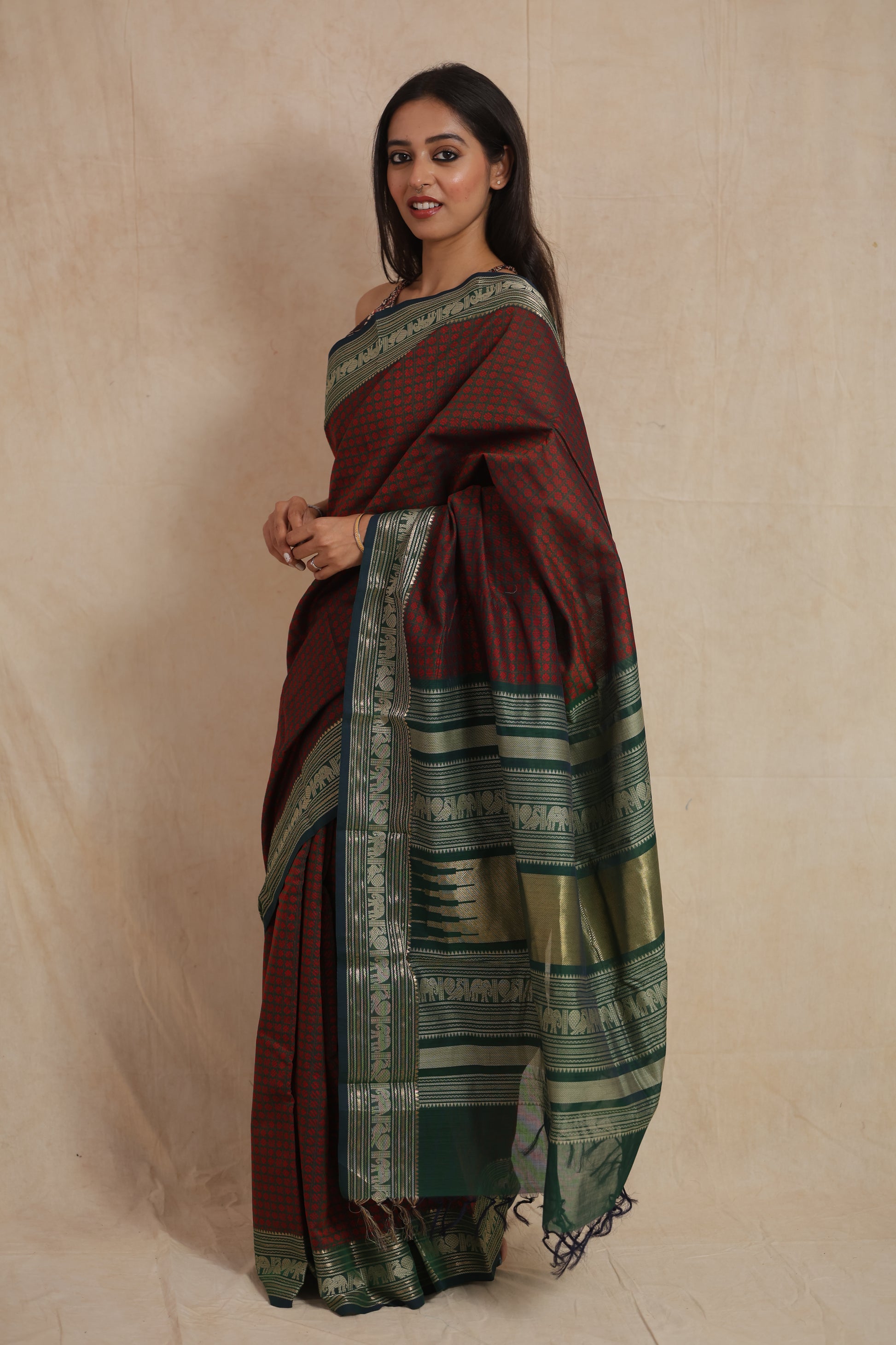 Side view of maroon Kanchipuram cotton saree with rich green border and pallu