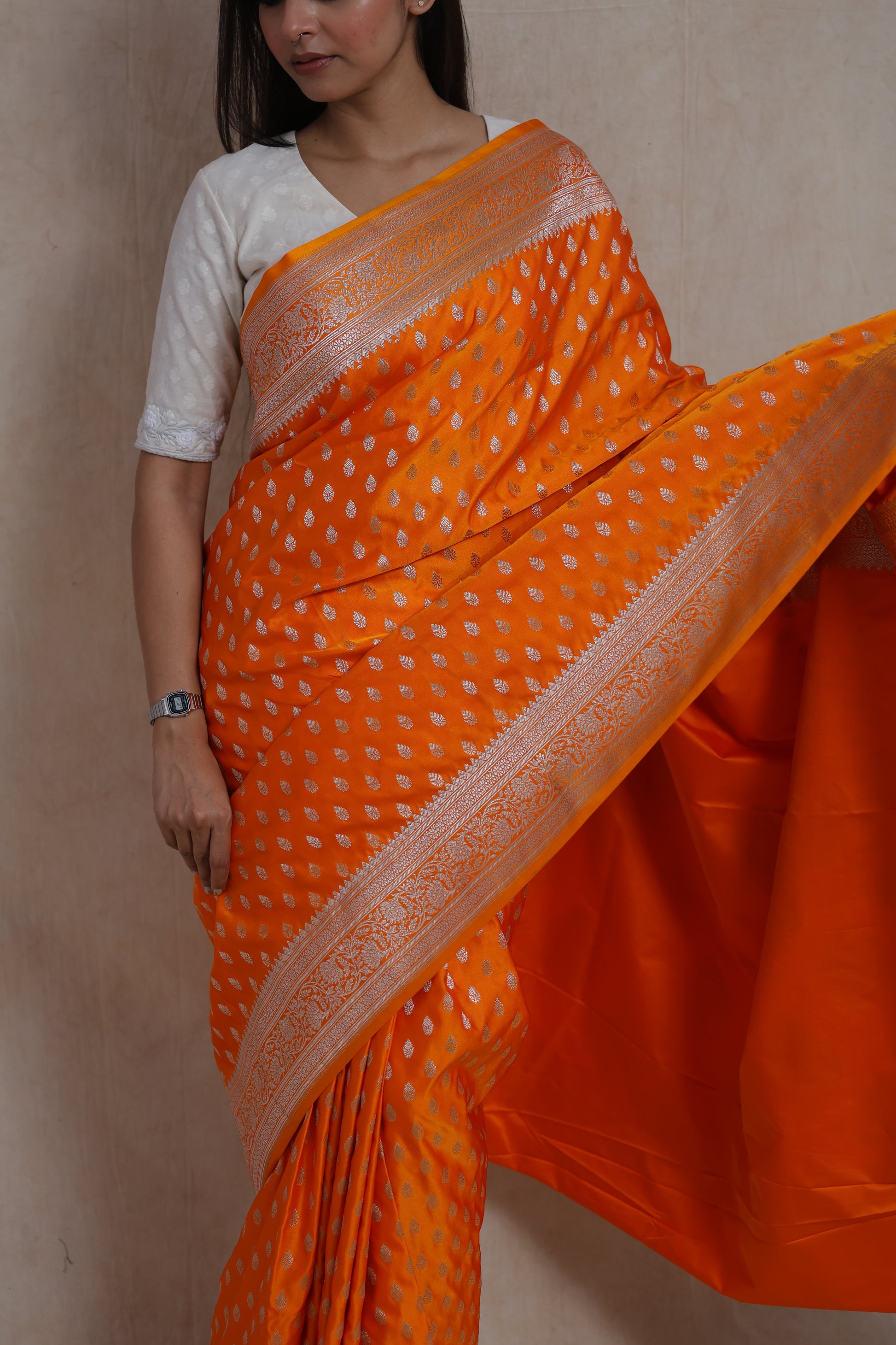 Portrait view of orange Banarasi art silk saree with detailed silver weaving and classic Banarasi craftsmanship