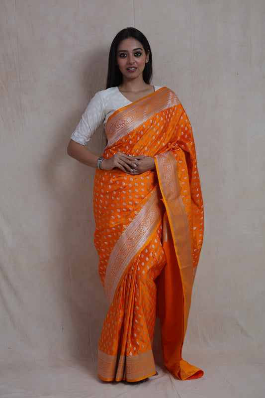 Front view of orange Banarasi art silk saree with elegant silver woven motifs and rich pallu