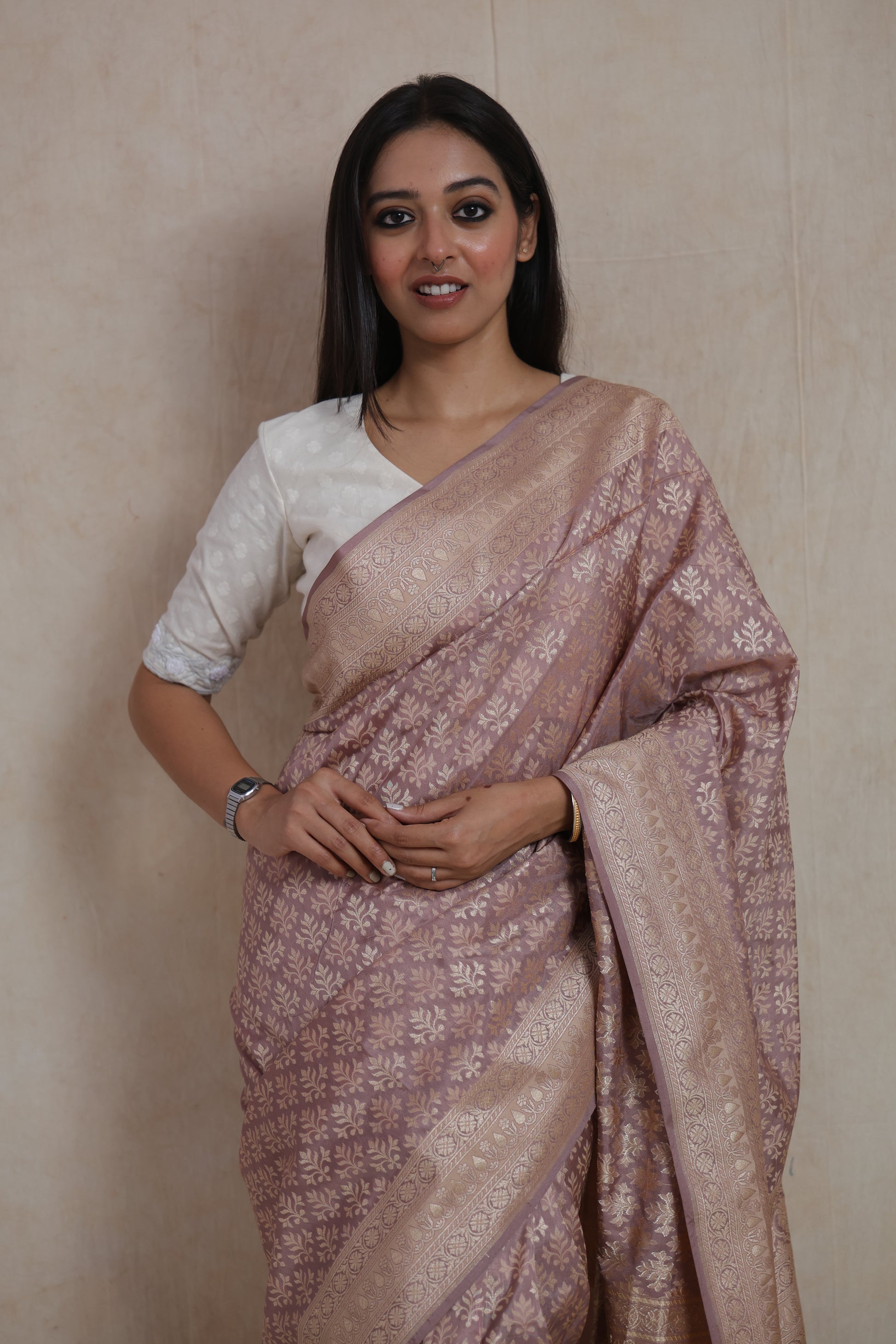 Close-up of dusty rose Banarasi art silk saree with floral woven motifs and ornate traditional border