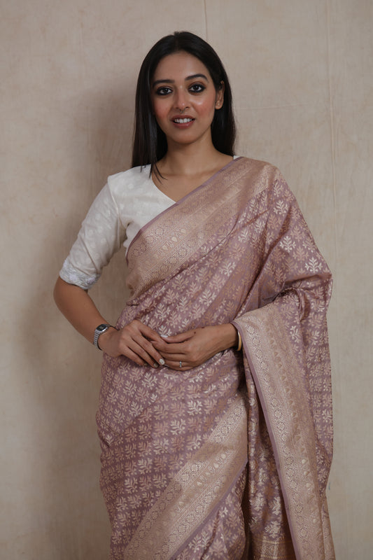 Close-up of dusty rose Banarasi art silk saree with floral woven motifs and ornate traditional border