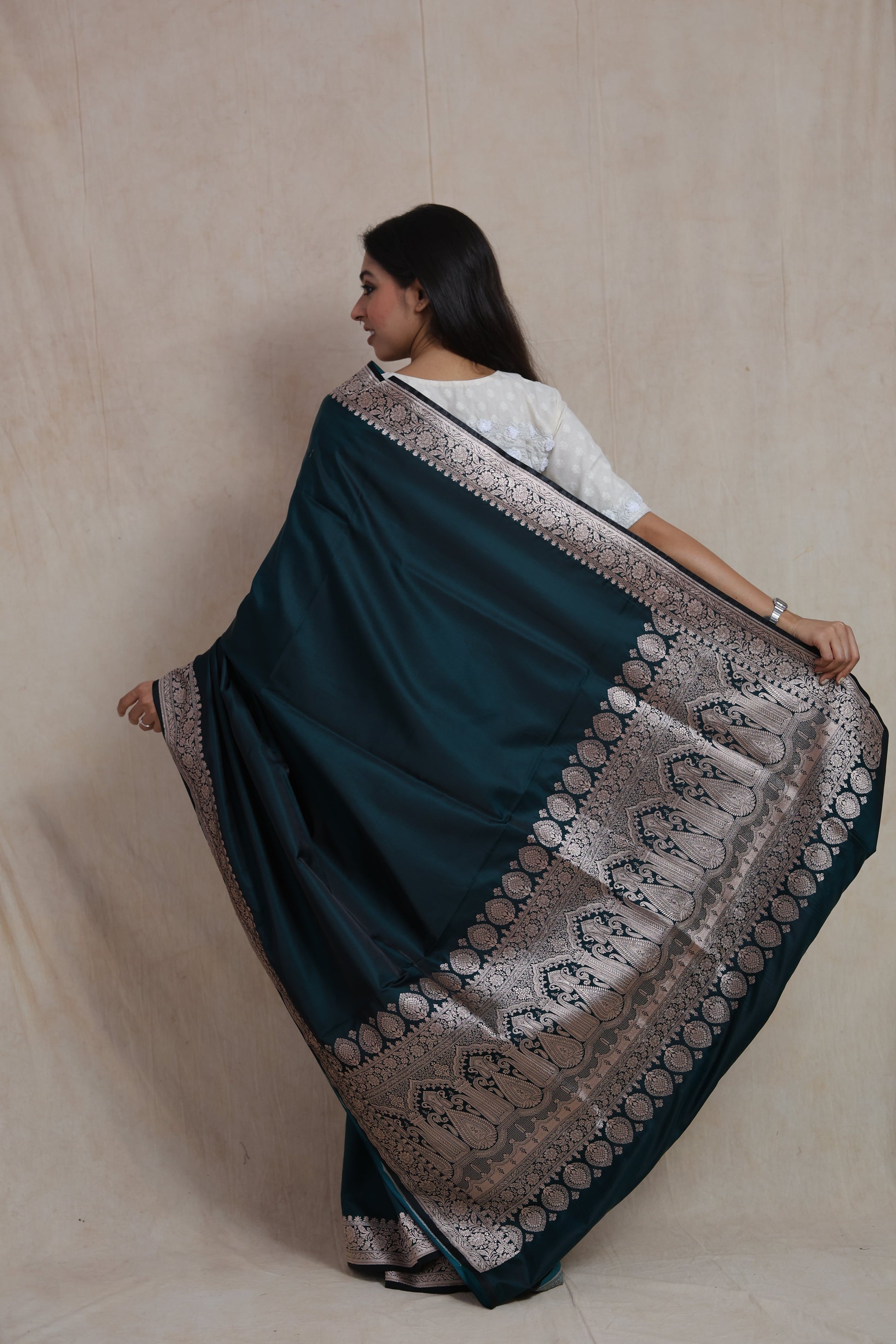 Back view of midnight teal Banarasi art silk saree featuring an ornate woven pallu and traditional border