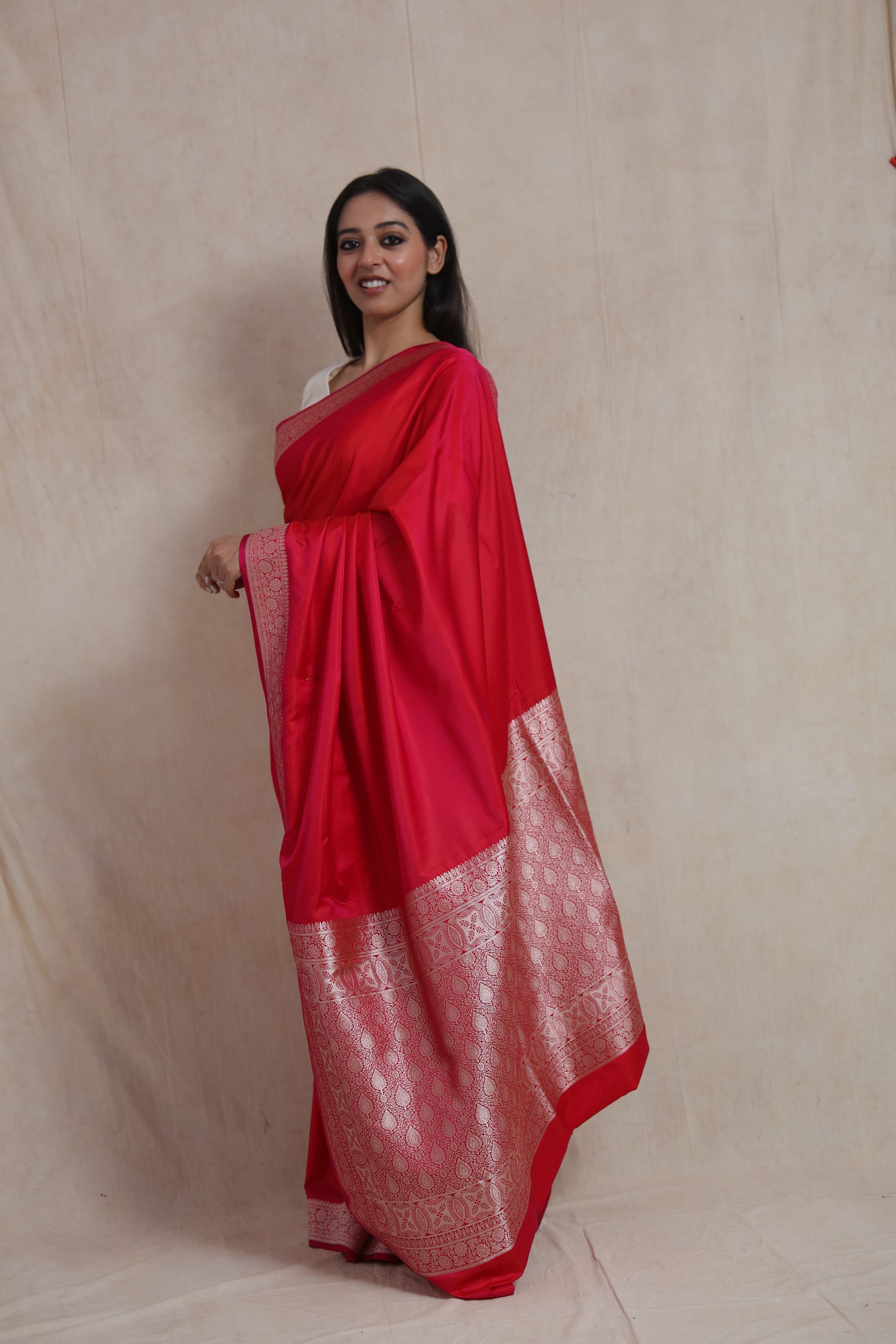 Side view of ruby red Banarasi silk saree with elegant silver zari border