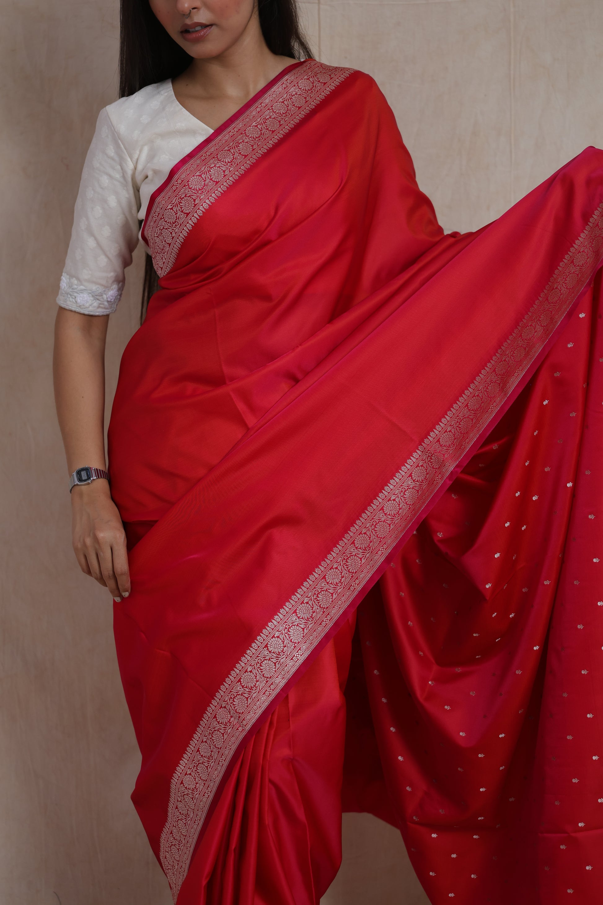 Close-up of the ruby red Banarasi silk saree drape with silver zari buttas