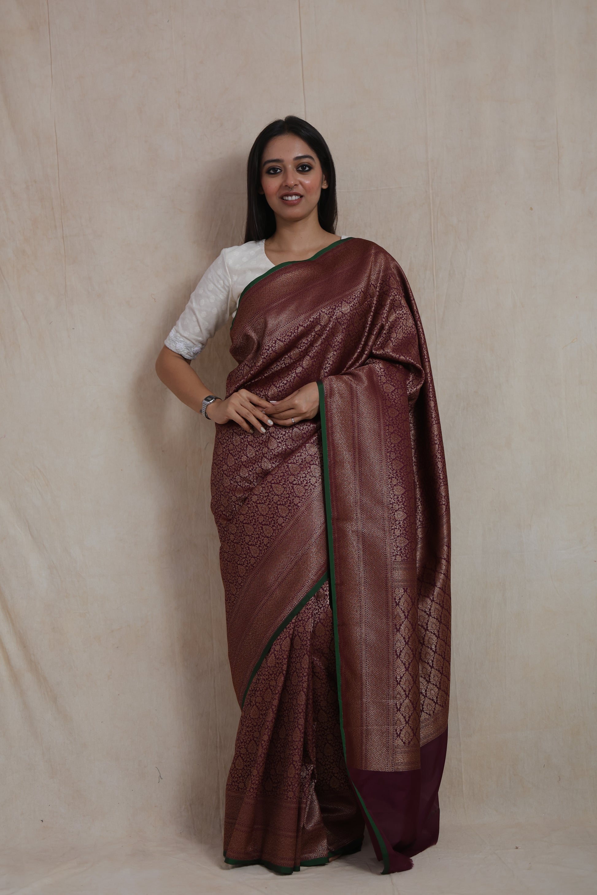 Model wearing wine purple Banarasi silk saree with antique gold floral weaving