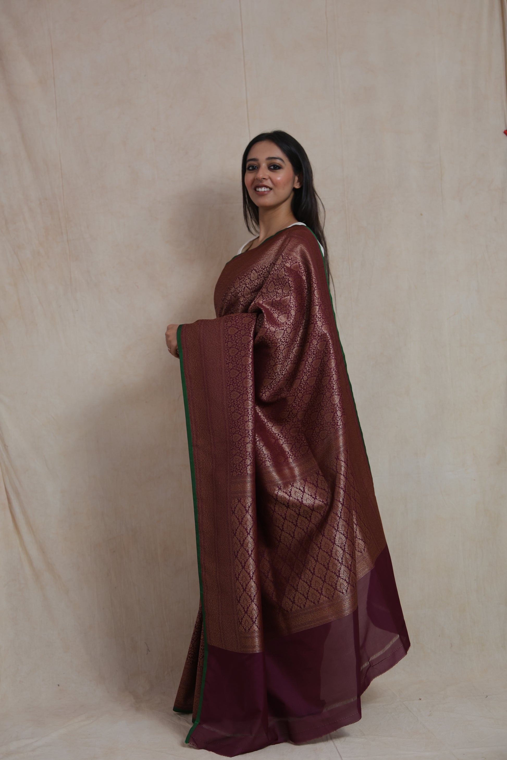 Side view of wine purple Banarasi silk saree with broad woven border and rich pallu