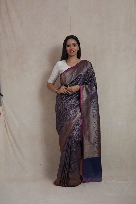 Model wearing royal navy blue Banarasi silk saree with antique gold floral weaving
