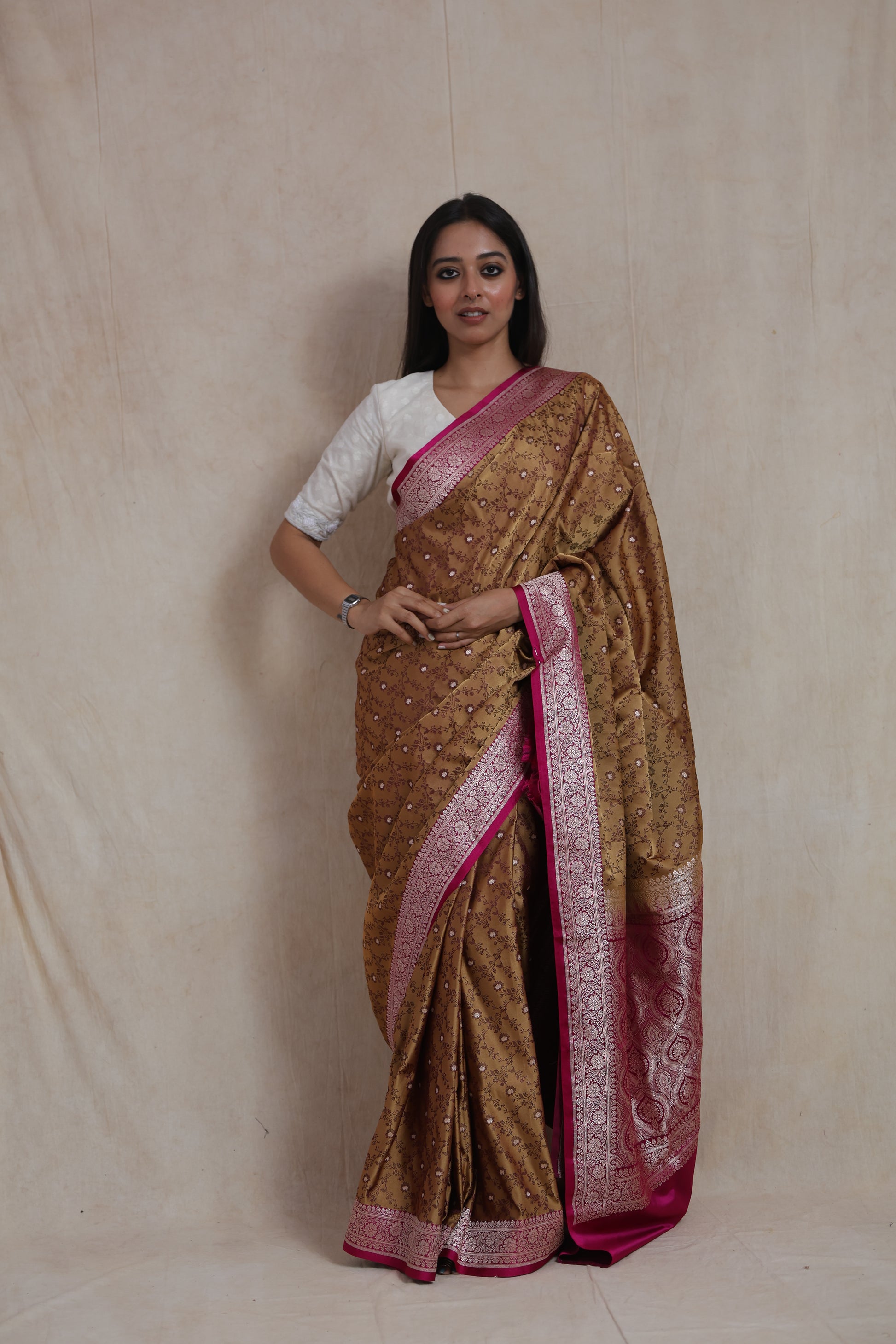 Model wearing golden beige Banarasi silk saree with pink woven border