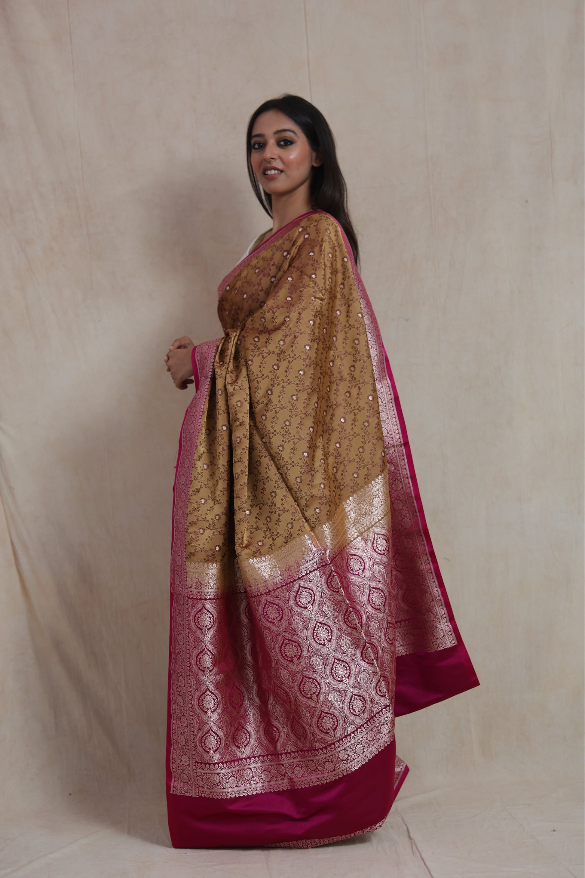 Side view of golden beige Banarasi silk saree showcasing rich pink pallu
